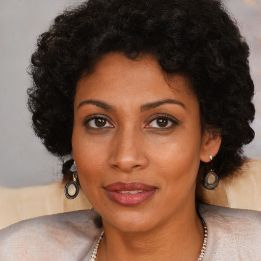 Joyful black young-adult female with long  brown hair and brown eyes