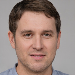 Joyful white young-adult male with short  brown hair and grey eyes