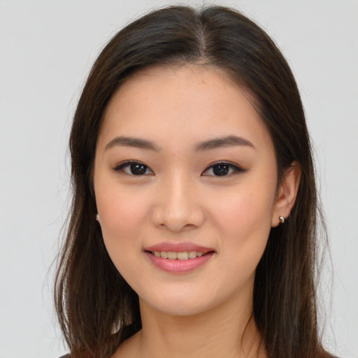 Joyful asian young-adult female with long  brown hair and brown eyes