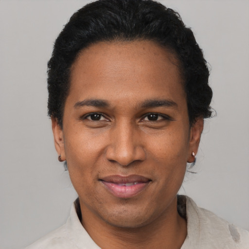 Joyful black adult male with short  black hair and brown eyes