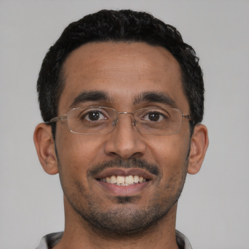 Joyful latino young-adult male with short  black hair and brown eyes