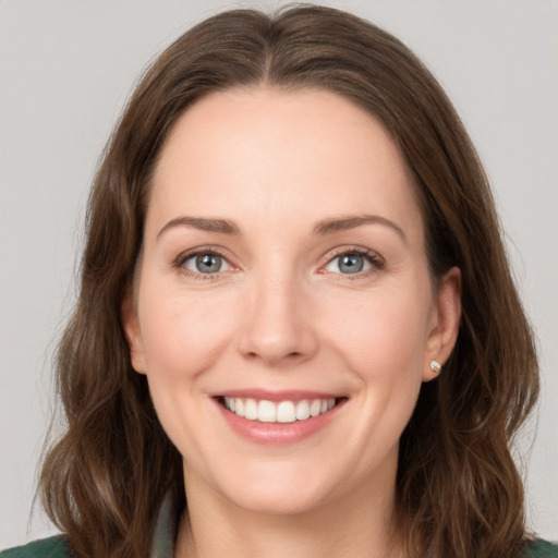 Joyful white young-adult female with medium  brown hair and green eyes