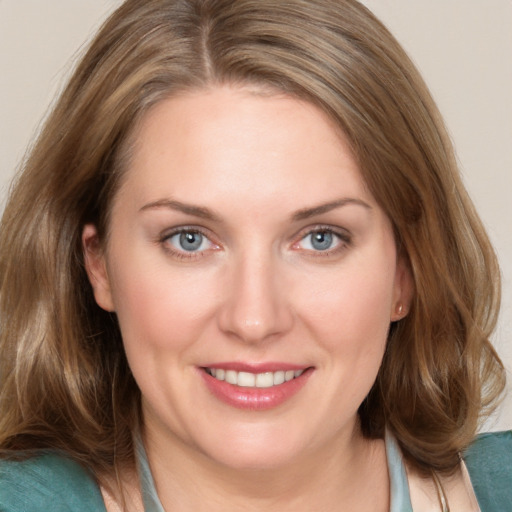 Joyful white young-adult female with medium  brown hair and blue eyes