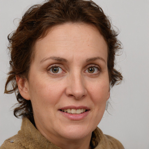 Joyful white adult female with medium  brown hair and blue eyes