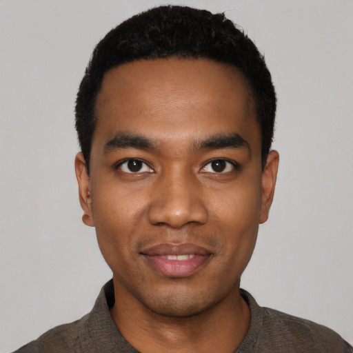 Joyful black young-adult male with short  black hair and brown eyes