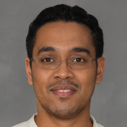 Joyful latino young-adult male with short  black hair and brown eyes