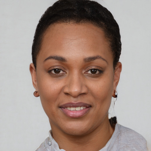 Joyful black young-adult female with short  brown hair and brown eyes