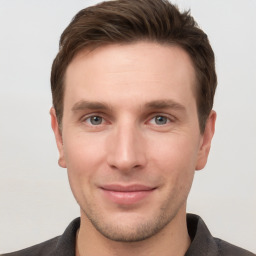 Joyful white young-adult male with short  brown hair and grey eyes