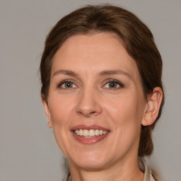 Joyful white adult female with medium  brown hair and grey eyes