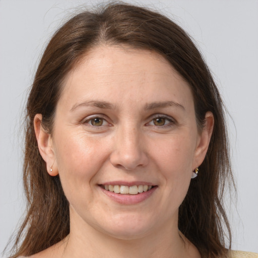 Joyful white adult female with long  brown hair and grey eyes