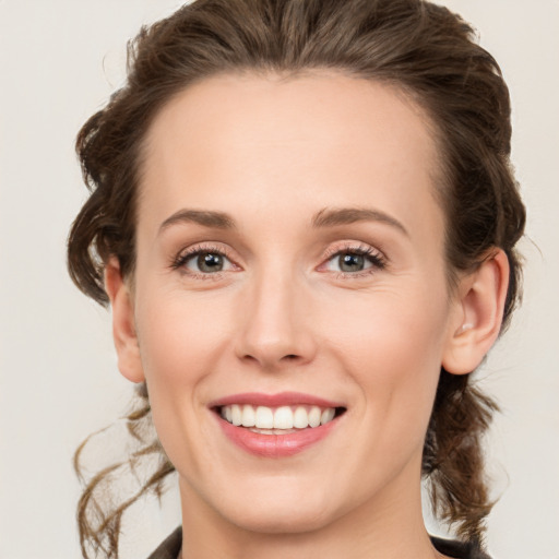 Joyful white young-adult female with medium  brown hair and green eyes