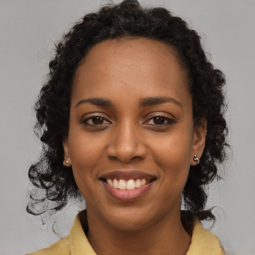 Joyful black young-adult female with medium  brown hair and brown eyes