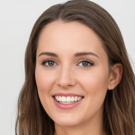 Joyful white young-adult female with long  brown hair and grey eyes