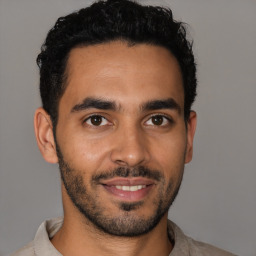 Joyful latino young-adult male with short  black hair and brown eyes