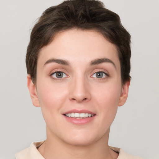 Joyful white young-adult female with short  brown hair and grey eyes