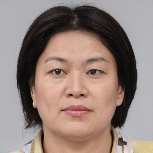 Joyful asian adult female with medium  brown hair and brown eyes