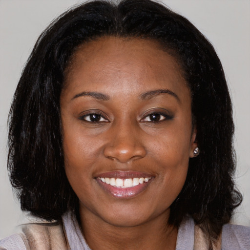 Joyful black young-adult female with medium  brown hair and brown eyes
