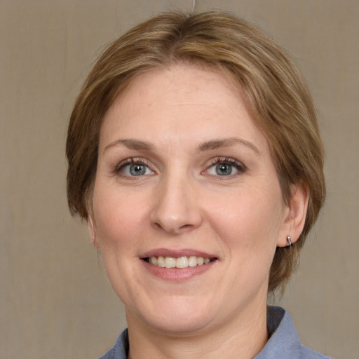 Joyful white adult female with medium  brown hair and grey eyes