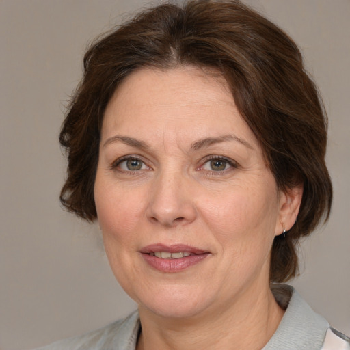 Joyful white adult female with medium  brown hair and grey eyes