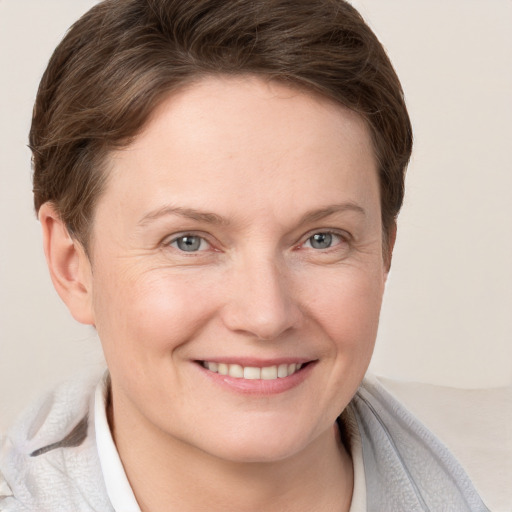 Joyful white young-adult female with short  brown hair and grey eyes