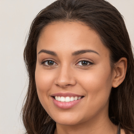 Joyful white young-adult female with long  brown hair and brown eyes