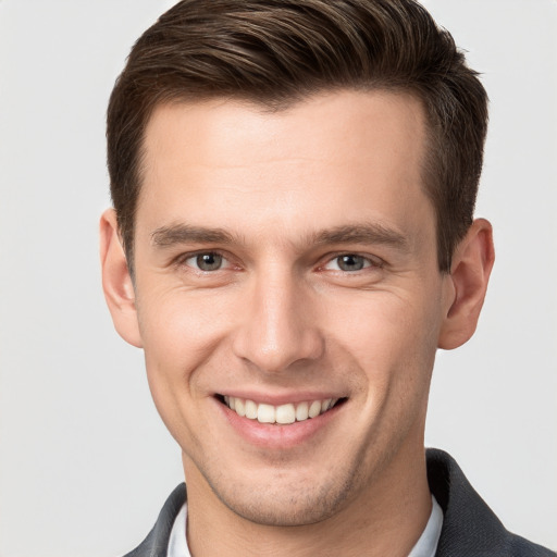 Joyful white young-adult male with short  brown hair and grey eyes