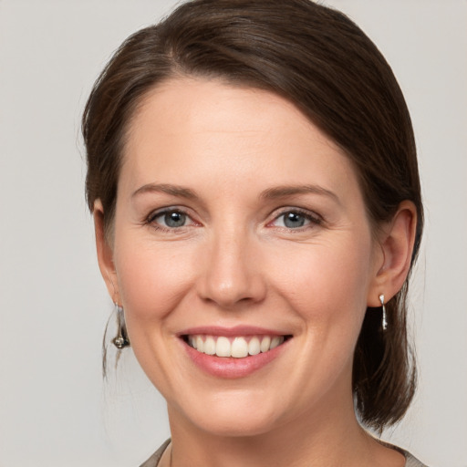 Joyful white young-adult female with medium  brown hair and grey eyes