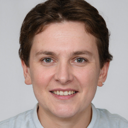 Joyful white young-adult male with short  brown hair and blue eyes