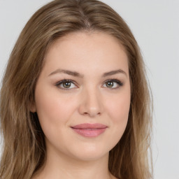 Joyful white young-adult female with long  brown hair and green eyes