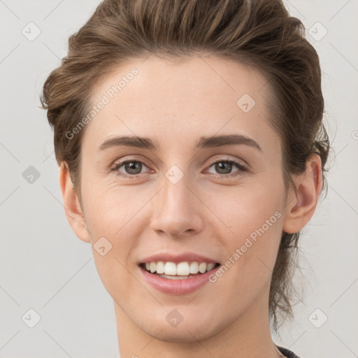 Joyful white young-adult female with short  brown hair and grey eyes