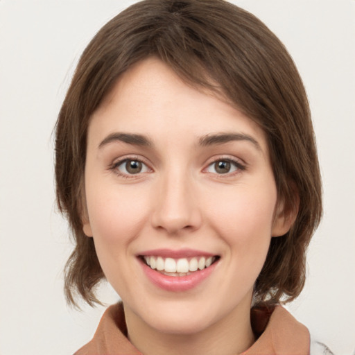 Joyful white young-adult female with medium  brown hair and green eyes