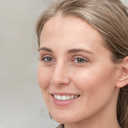 Joyful white young-adult female with long  brown hair and blue eyes