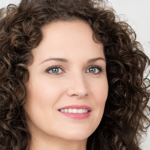 Joyful white young-adult female with long  brown hair and green eyes