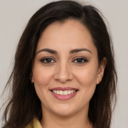 Joyful white young-adult female with long  brown hair and brown eyes