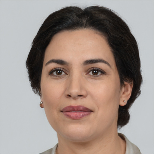 Joyful latino adult female with medium  brown hair and brown eyes