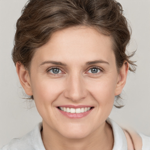 Joyful white young-adult female with medium  brown hair and blue eyes