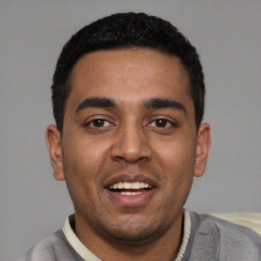 Joyful latino young-adult male with short  black hair and brown eyes