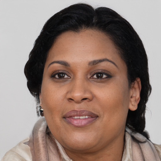 Joyful black adult female with long  brown hair and brown eyes