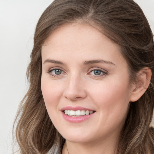 Joyful white young-adult female with long  brown hair and blue eyes