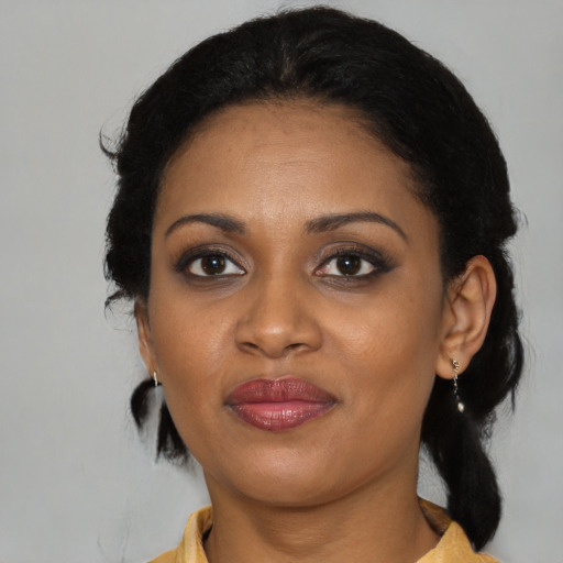 Joyful black young-adult female with medium  black hair and brown eyes
