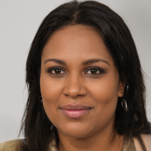 Joyful black young-adult female with long  brown hair and brown eyes