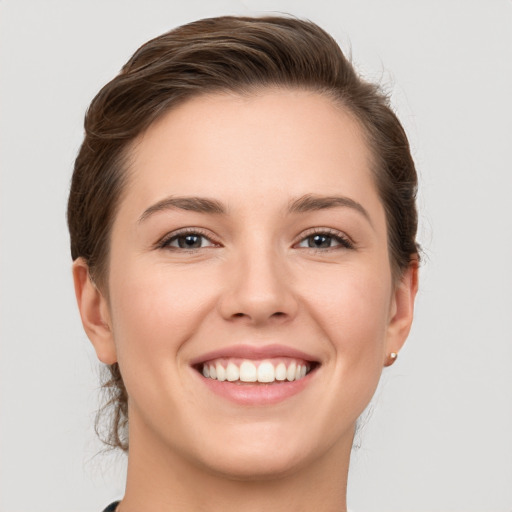 Joyful white young-adult female with short  brown hair and grey eyes