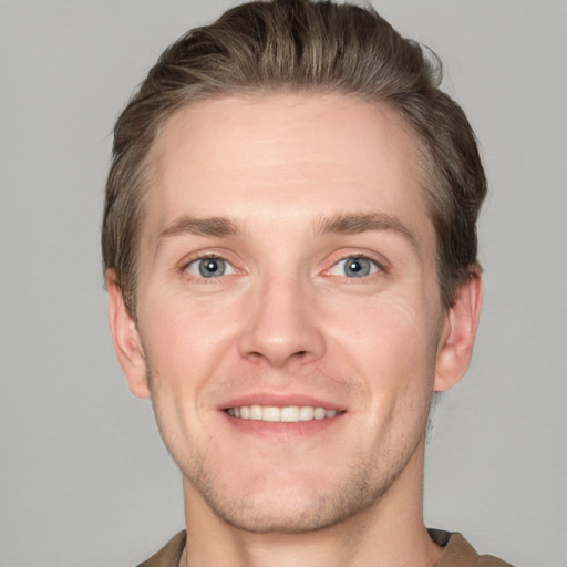 Joyful white young-adult male with short  brown hair and grey eyes