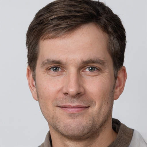 Joyful white adult male with short  brown hair and grey eyes