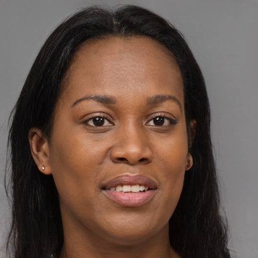 Joyful black young-adult female with long  brown hair and brown eyes