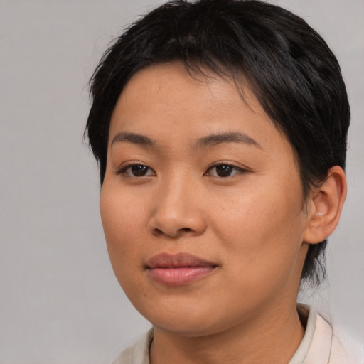 Joyful asian young-adult female with short  brown hair and brown eyes