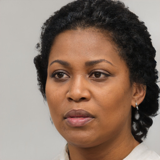 Joyful black adult female with short  black hair and brown eyes