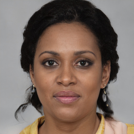 Joyful black adult female with medium  brown hair and brown eyes