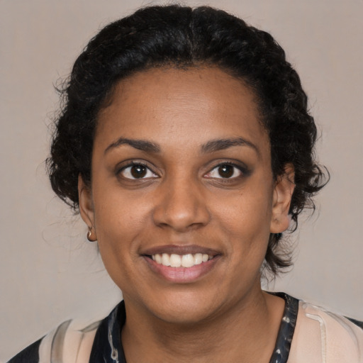 Joyful black young-adult female with medium  black hair and brown eyes