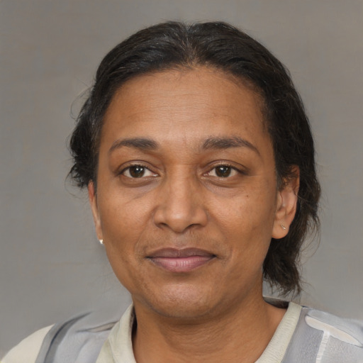 Joyful black adult female with medium  brown hair and brown eyes